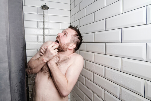 man surprised with cold water in shower